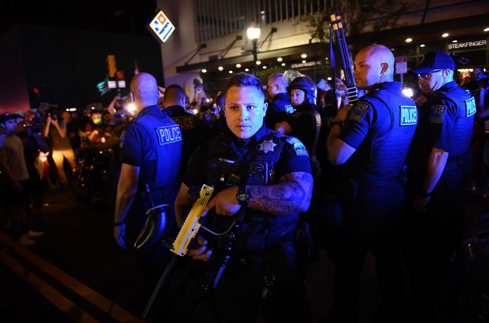 Police officers march towards the crowd where Trump supporters and anti-Trump protestors now roam together in Tulsa, Oklahoma where Donald Trump held a campaign rally earlier on June 20, 2020. - Hundreds of supporters lined up early for Donald Trump's first political rally in months, saying the risk of contracting COVID-19 in a big, packed arena would not keep them from hearing the president's campaign message. (Photo by Brendan Smialowski / AFP) (Photo by BRENDAN SMIALOWSKI/AFP via Getty Images)