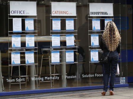 FILE PHOTO - A woman looks at job advertisements in a window in Leicester, central England September 14, 2011. REUTERS/Darren Staples