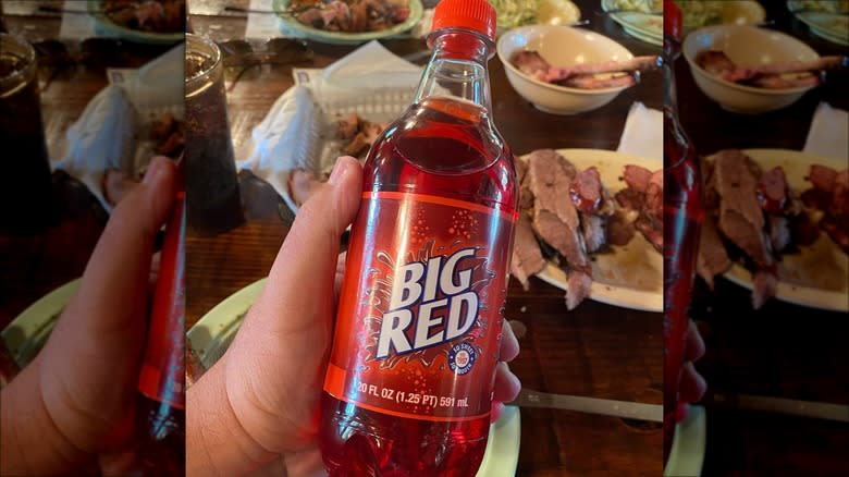 person holding big red soda