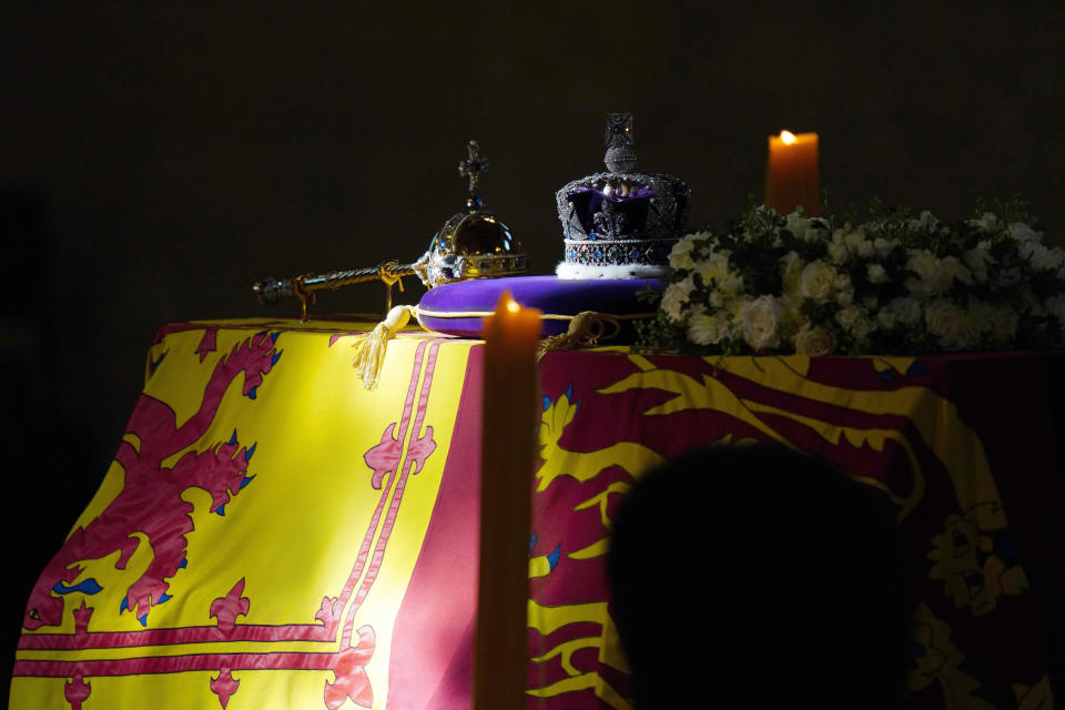 FILE A ray of sun shines on the coffin of Queen Elizabeth II, draped in the Royal Standard with the Imperial State Crown and the Sovereign's orb and sceptre, during it's lying in state on the catafalque in Westminster Hall, at the Palace of Westminster, in London, Saturday, Sept. 17, 2022. When Queen Elizabeth II’s grandfather, King George V, died in 1936, life in Britain is unrecognizable to people today. But despite almost a century of change, the images from the queen’s lying in state this week are almost exact copies of those from George V’s time. (Carl Court/Pool Photo via AP, File)