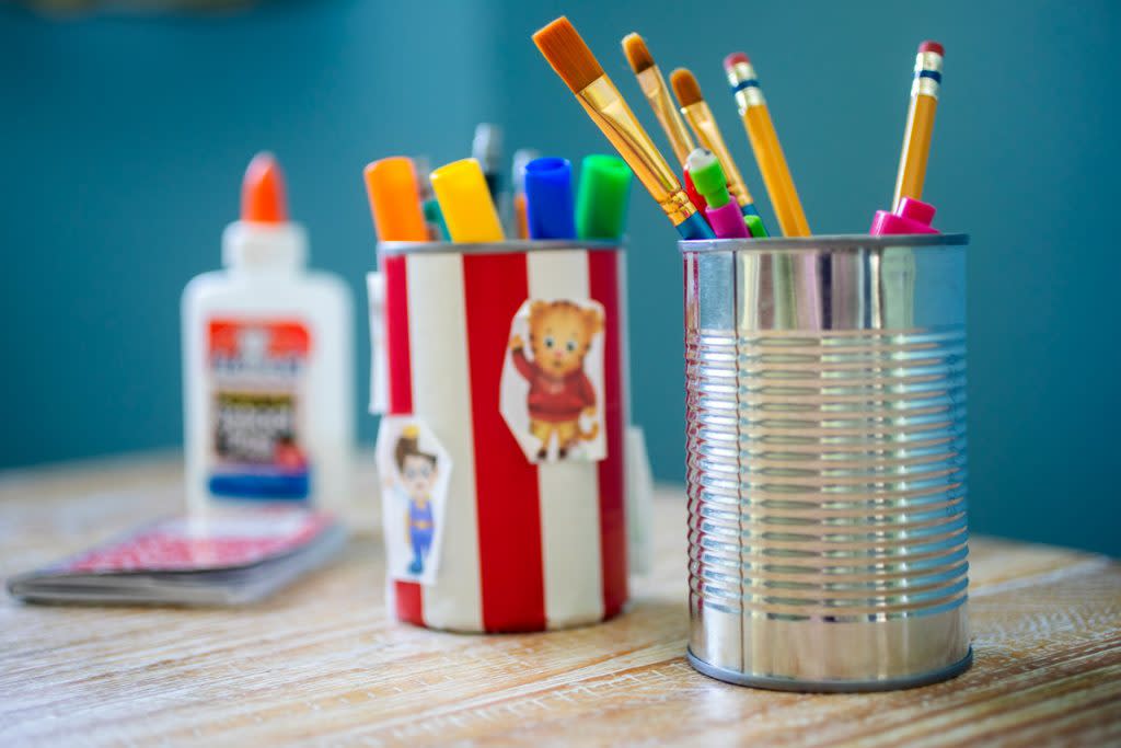 Old cans are used to store pencils and markers.