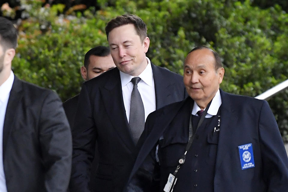 Tesla CEO Elon Musk, second from right, arrives at U.S. District Court Wednesday, Dec. 4, 2019, in Los Angeles. Musk is going on trial for his troublesome tweets in a case pitting the billionaire against a British diver he allegedly dubbed a pedophile. (AP Photo/Mark J. Terrill)
