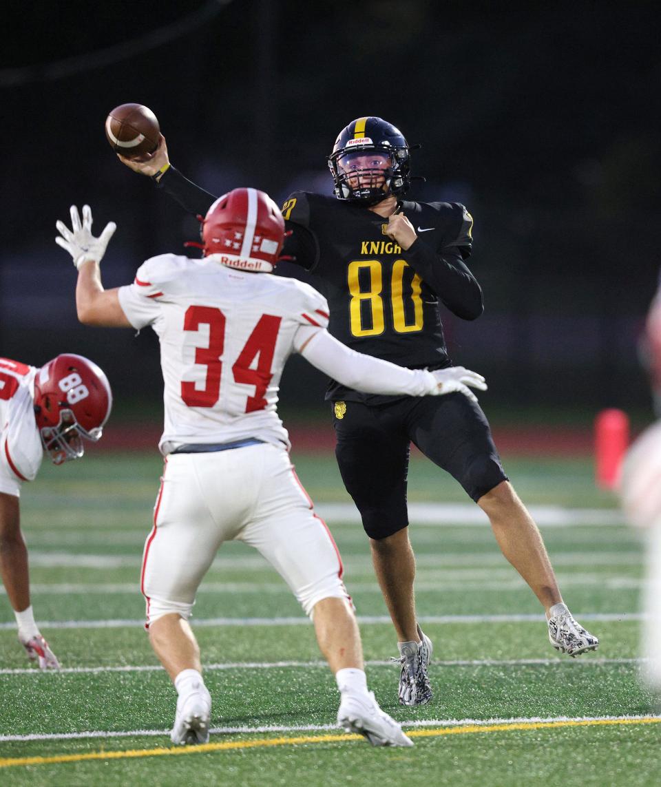 McQuaid quarterback Will DiMarco has to pass over Fairport defender Joseph Roselli.