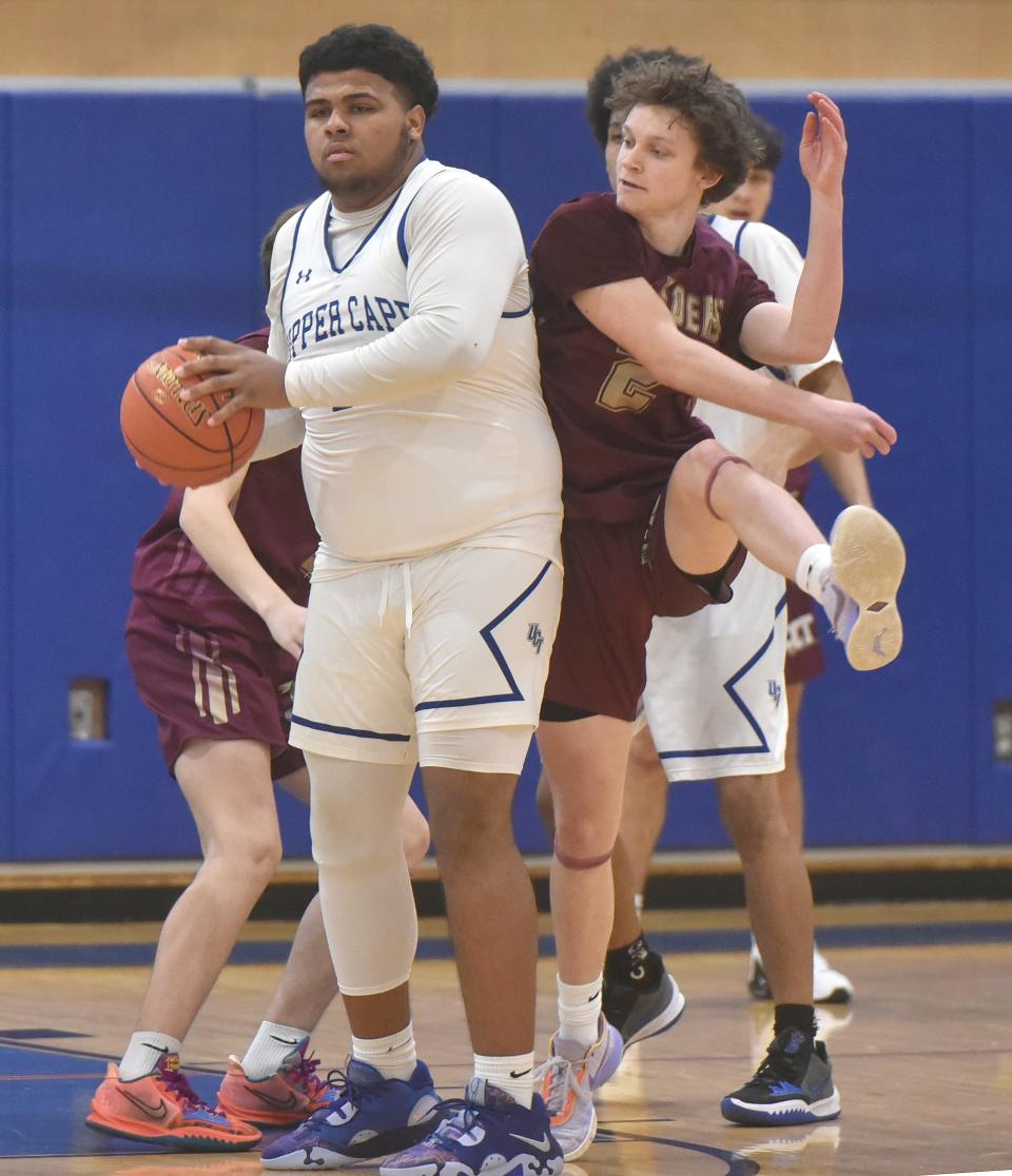 Upper Cape Tech's Damin Tavares, looks for an outlet as Cape Tech's Trevor Ryone tries to break up the play as Upper Cape Tech played host to Cape Cod Tech in Bourne in this Jan. 21 game action.