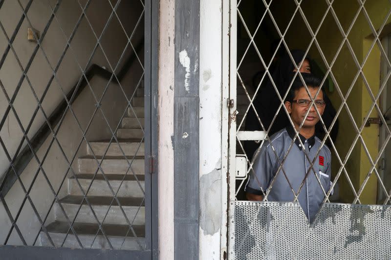 Rohingya refugee and activist Zafar Ahmad Abdul Ghani and his wife look out from their home in Kuala Lumpur