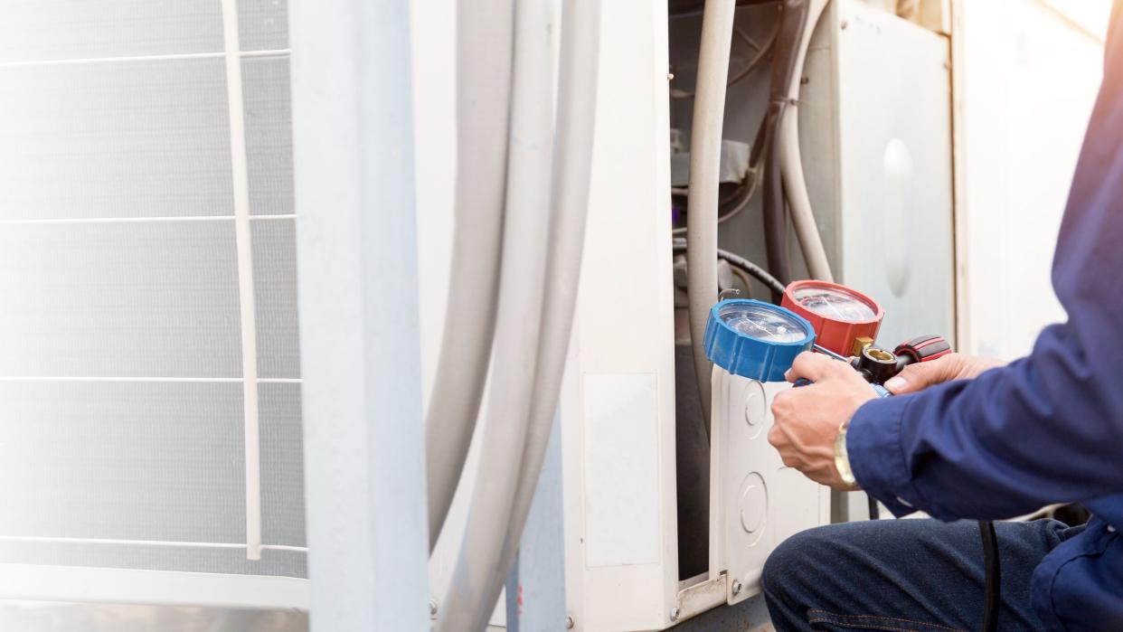 Technician is checking air conditioner ,measuring equipment for filling air conditioners.