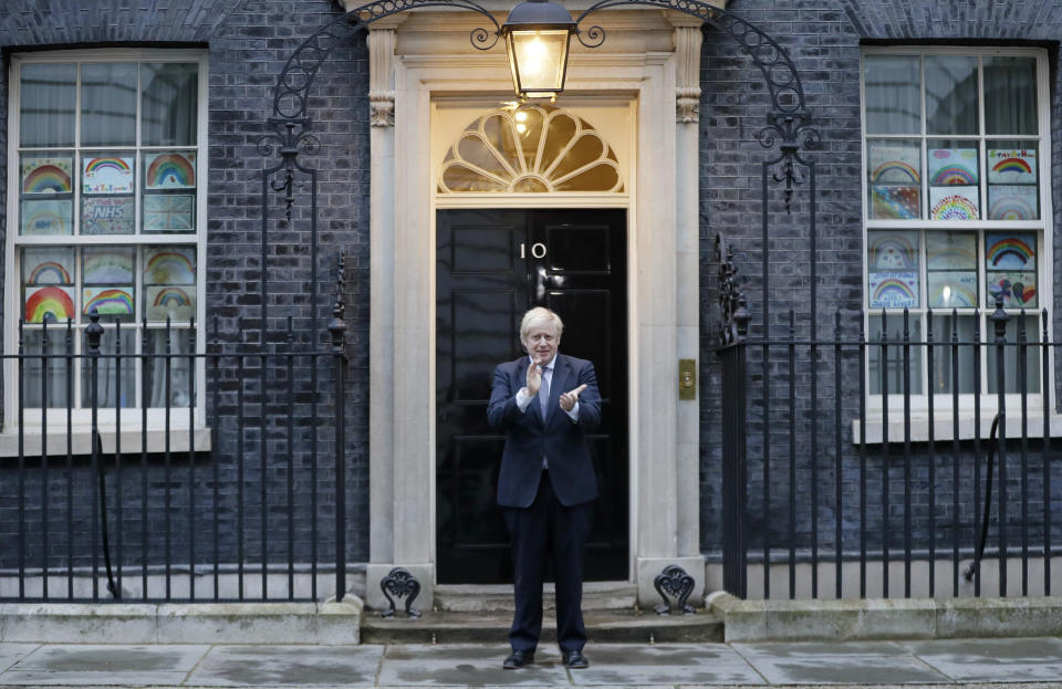 Britain's Prime Minister Boris Johnson applauds on the doorstep of 10 Downing Street in London during the weekly "Clap for our Carers" Thursday, April 30, 2020. The COVID-19 coronavirus pandemic has prompted a public display of appreciation for care workers. The applause takes place across Britain every Thursday at 8pm local time to show appreciation for healthcare workers, emergency services, armed services, delivery drivers, shop workers, teachers, waste collectors, manufacturers, postal workers, cleaners, vets, engineers and all those helping people with coronavirus and keeping the country functioning while most people stay at home in the lockdown. (AP Photo/Kirsty Wigglesworth)