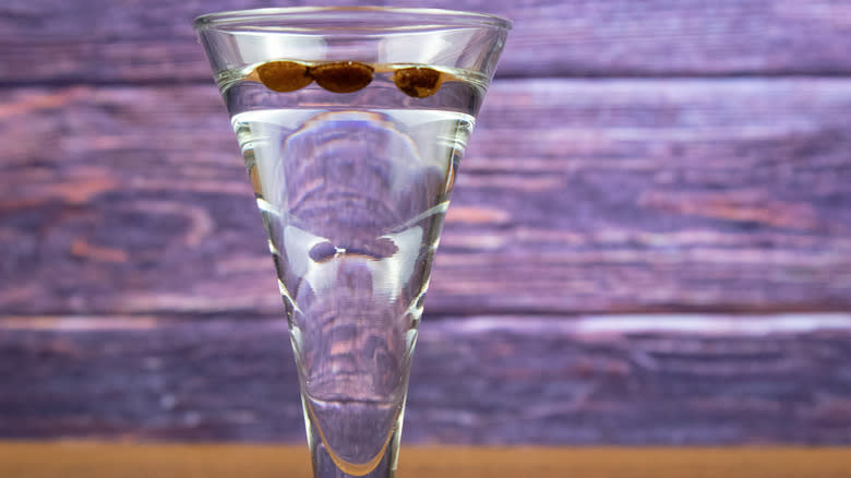 Sambuca glass with floating coffee beans.