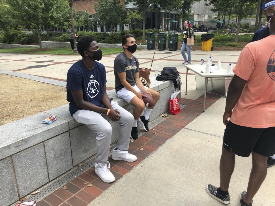 Daniel Akinola, a junior aerospace engineering major from North Carolina, talks to friends on the first day of classes Monday, August 17, 2020, at Georgia Tech in Atlanta. More of Georgia's public universities are opening for the fall term, trying to balance concern about COVID-19 infections against a mandate for on-campus classes citing financial needs and student desires (AP Photo/Jeff Amy)