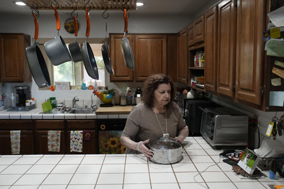 Maria Jackson unpacks kitchen items as she moves into a home where she is renting a small room Monday, May 8, 2023, in Las Vegas. Jackson, a longtime massage therapist, lost her customers when the pandemic triggered a statewide shutdown in March 2020 and was evicted from her apartment earlier this year. (AP Photo/John Locher)