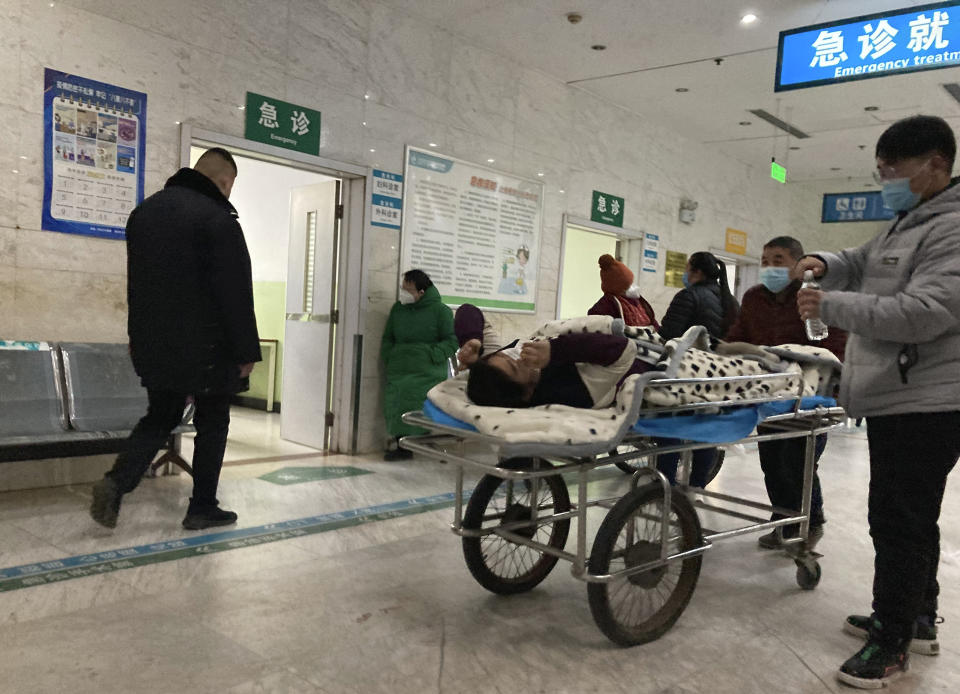 FILE - A patient is wheeled through the emergency room at the Zhuozhou Hospital in Zhuozhou city of the Baoding prefecture in northern China's Hebei province on Wednesday, Dec. 21, 2022. Nearly three years after it was first identified in China, the coronavirus is now spreading through the vast country. Experts predict difficult months ahead for its 1.4 billion people. (AP Photo/Dake Kang)