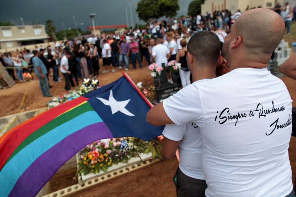 <p>Friends of Jonathan Camuy, one of the victims of the shooting at the Pulse night club in Orlando, embrace during his funeral in his hometown of Camuy, Puerto Rico, June 22, 2016. The shirt reads, “We will always remember you Jonathan”. (REUTERS/Alvin Baez) </p>