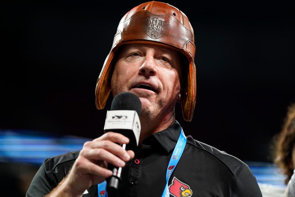 Louisville head coach Jeff Brohm stands on a stage near the Old Leather Helmet trophy after an NCAA college football game against Georgia Tech, Friday, Sept. 1, 2023, in Atlanta. Louisville won 39-34. (AP Photo/Mike Stewart)