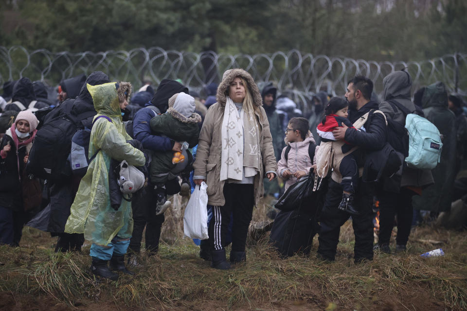 Migrants from the Middle East and elsewhere gather at the Belarus-Poland border near Grodno, Belarus, Monday, Nov. 8, 2021. Poland increased security at its border with Belarus, on the European Union's eastern border, after a large group of migrants in Belarus appeared to be congregating at a crossing point, officials said Monday. The development appeared to signal an escalation of a crisis that has being going on for months in which the autocratic regime of Belarus has encouraged migrants from the Middle East and elsewhere to illegally enter the European Union, at first through Lithuania and Latvia and now primarily through Poland. (Leonid Shcheglov/BelTA via AP)
