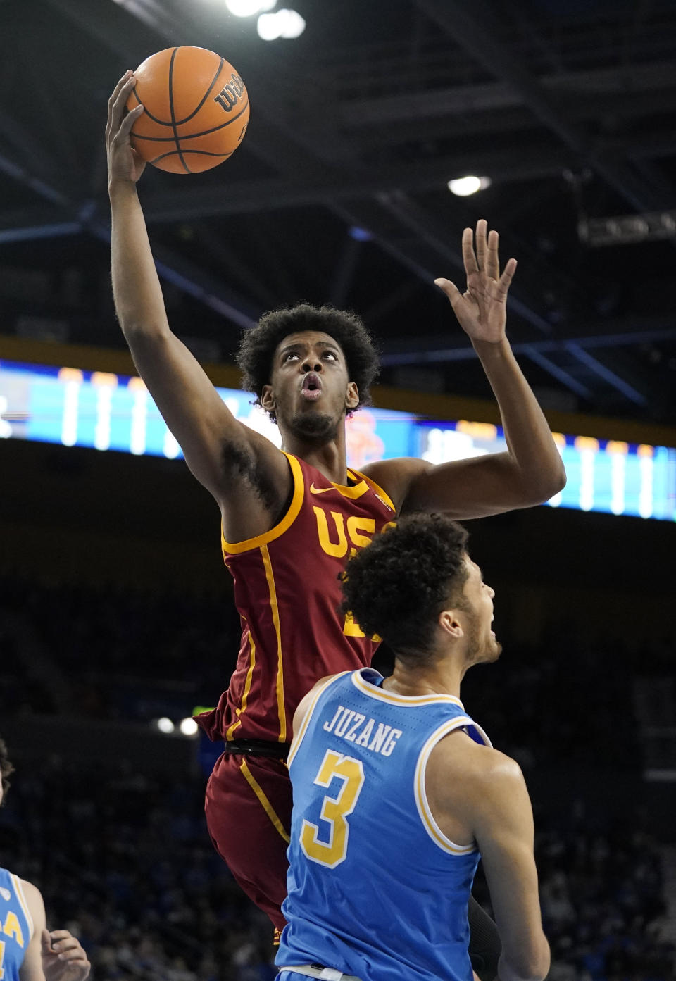 Southern California forward Joshua Morgan, left, shoots as UCLA guard Johnny Juzang defends during the first half of an NCAA college basketball game Saturday, March 5, 2022, in Los Angeles. (AP Photo/Mark J. Terrill)