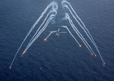 A U.S. Navy MH-60R Sea Hawk helicopter from the "Blue Hawks" of Helicopter Maritime Strike Squadron 78 fires chaff flares during a training exercise near the aircraft carrier USS Carl Vinson (CVN 70) in the Philippine Sea. U.S. Navy/Mass Communication Specialist 2nd Class Sean M. Castellano/via REUTERS