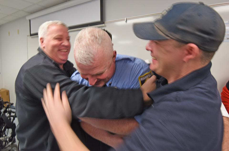 Matthew Shafley is congratulated with a hug from his firefighting peers during a previous promotion ceremony at the Main Street Fire Station.