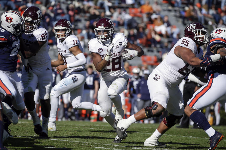 Texas A&M running back Isaiah Spiller (28) carries the ball during the first half of an NCAA college football game against Auburn on Saturday, Dec. 5, 2020, in Auburn, Ala. (AP Photo/Butch Dill)