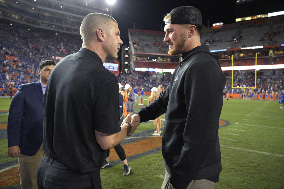 Florida head coach Billy Napier, left, is congratulated by former Florida player and current Tampa Bay Buccaneers quarterback Kyle Trask after getting a win over Utah in an NCAA college football game, Saturday, Sept. 3, 2022, in Gainesville, Fla. (AP Photo/Phelan M. Ebenhack)