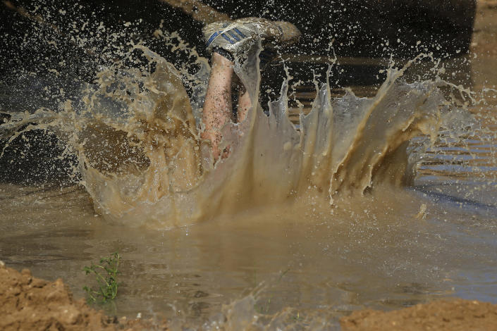 <p>A participant dives into the mud pool during the Mud Day athletic event at El Goloso Military base on the outskirts of Madrid, Spain, June 11, 2016. (AP Photo/Paul White) </p>