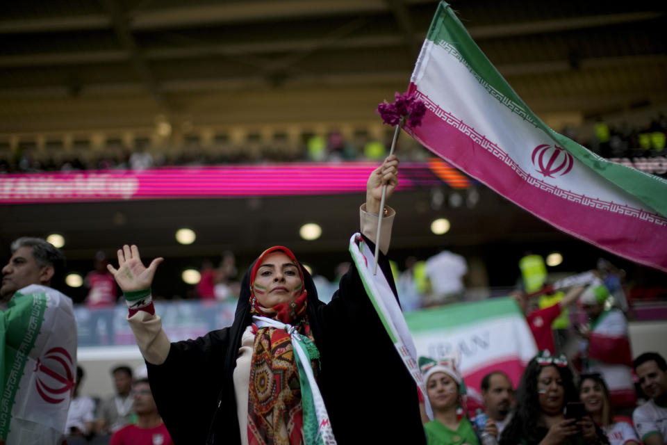 A soccer fan holds a flag from Iran prior to the World Cup group B soccer match between Wales and Iran, at the Ahmad Bin Ali Stadium in Al Rayyan , Qatar, Friday, Nov. 25, 2022. (AP Photo/Francisco Seco)