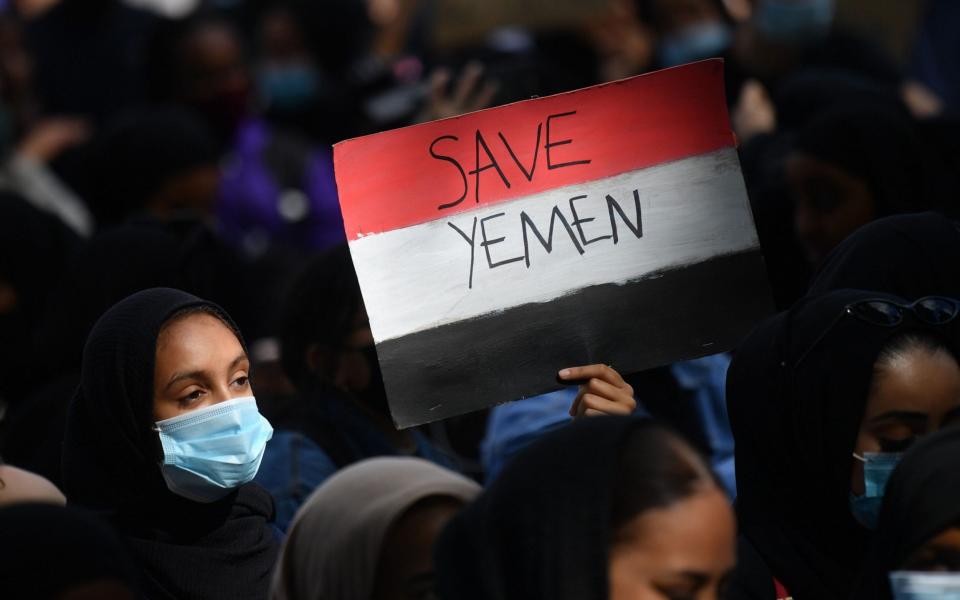 A protester holds a Yemeni flag-themed placard in Parliament Square in London  - JUSTIN TALLIS/AFP via Getty Images