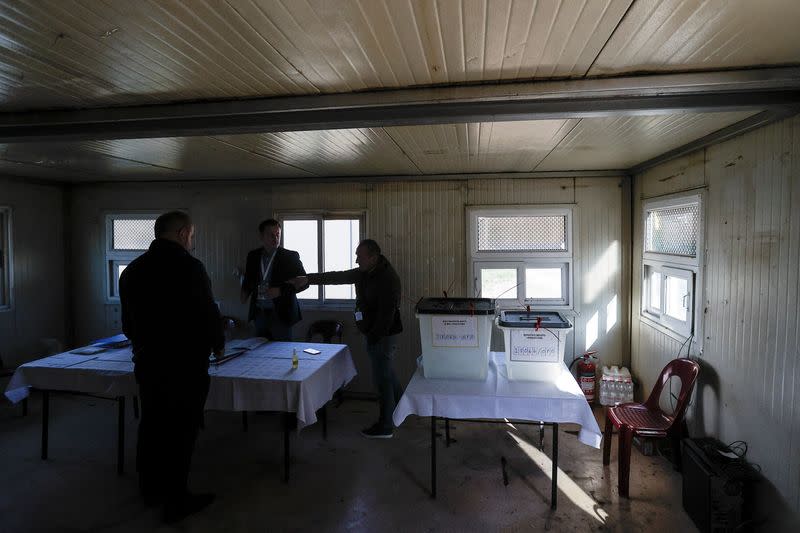 Members of the central election commission prepare a container used as an alternative voting center, in Zubin Potok