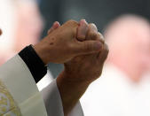 <p>Members of the clergy hold hands during a vigil at Guardian Angel Cathedral for the victims of the Route 91 Harvest country music festival shootings on October 2, 2017 in Las Vegas, Nevada. (Photo: Denise Truscello/Getty Images) </p>