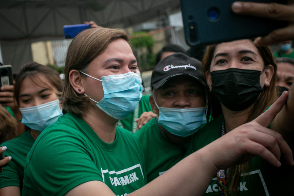 This photo taken on November 9, 2021 shows Sara Duterte (L), mayor and daughter of outgoing Philippines President Rodrigo Duterte, posing for a selfie with city hall employees in Davao city, on the southern island of Mindanao. (Photo by Manman Dejeto / AFP) (Photo by MANMAN DEJETO/AFP via Getty Images)