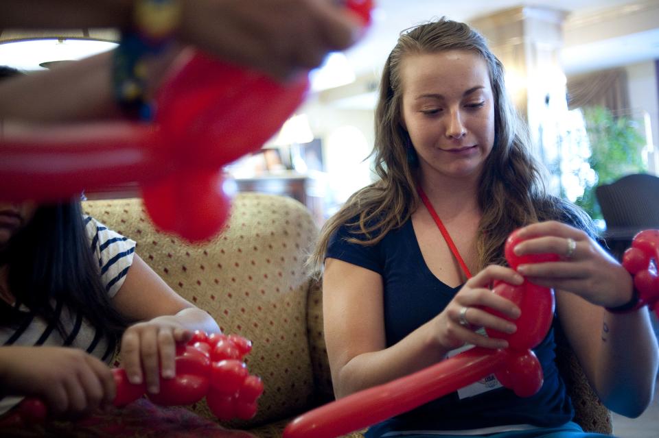 In a July 31, 2012 photo, Morgan Thacker is taught by fellow campers how to make balloon animals at the third annual Clown Campin' in Ontario, Calif. Thacker, of Bristol, Tenn., traveled on a scholarship to attend the week long event in clown schooling. (AP Photo/Grant Hindsley)