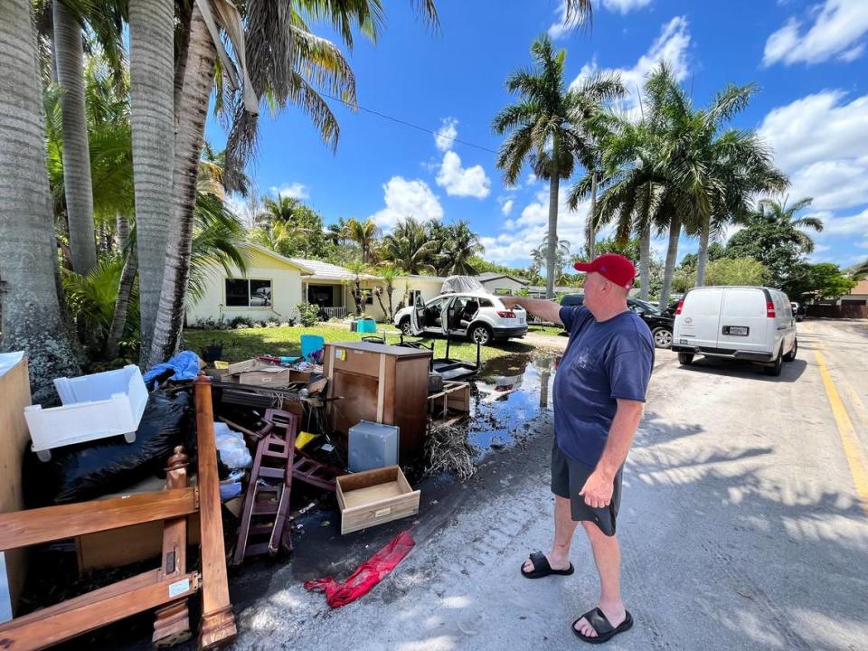 Lance Peterman, 56, stands in front of his waterlogged belongings and ruined vehicles after his Fort Lauderdale home saw three feet of flooding. He found his elderly mother floating on a mattress in the living room Wednesday evening.