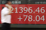 A man walks past an electronic stock board showing Japan's Nikkei 225 index at a securities firm in Tokyo Tuesday, Sept. 10, 2019. Asian shares were mixed Tuesday after a day of listless trading on Wall Street, as investors awaited signs on global interest rates. (AP Photo/Eugene Hoshiko)