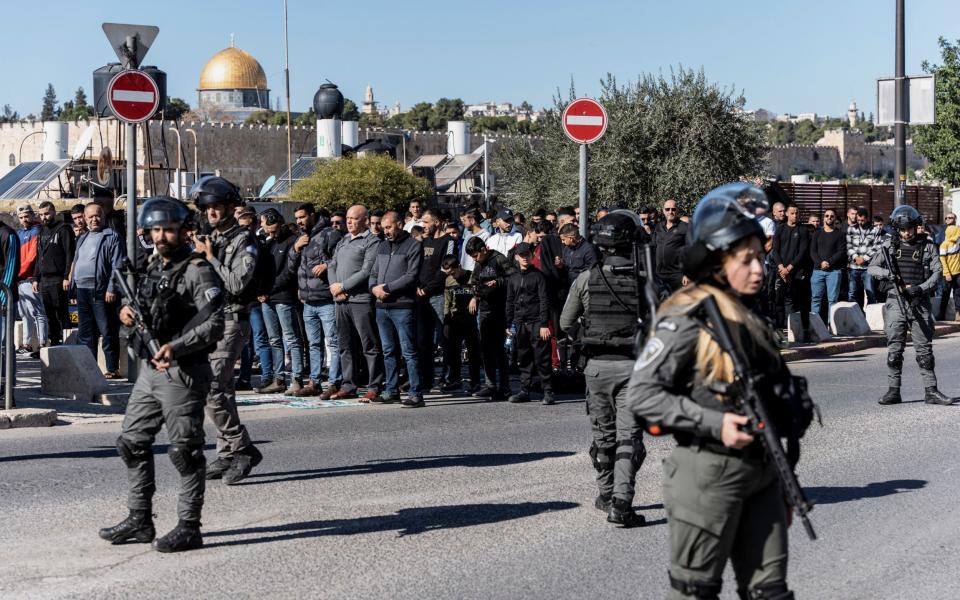 Israeli border police officers stand with weapons in Jerusalem as Muslim Palestinians hold Friday prayers