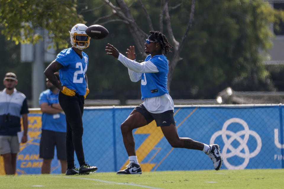 Los Angeles Chargers safeties Derwin James Jr., right, throws a ball as Nasir Adderley (24) looks on during the NFL football team's training camp, Wednesday, July 27, 2022, in Costa Mesa, Calif. (AP Photo/Ringo H.W. Chiu)