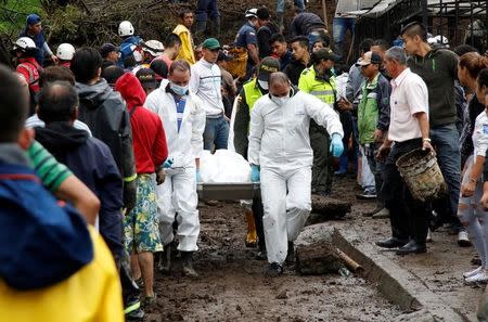 Rescue members recover a body in a house after mudslides, caused by heavy rains leading several rivers to overflow, pushing sediment and rocks into buildings and roads, in Manizales, Colombia April 19, 2017. REUTERS/Santiago Osorio