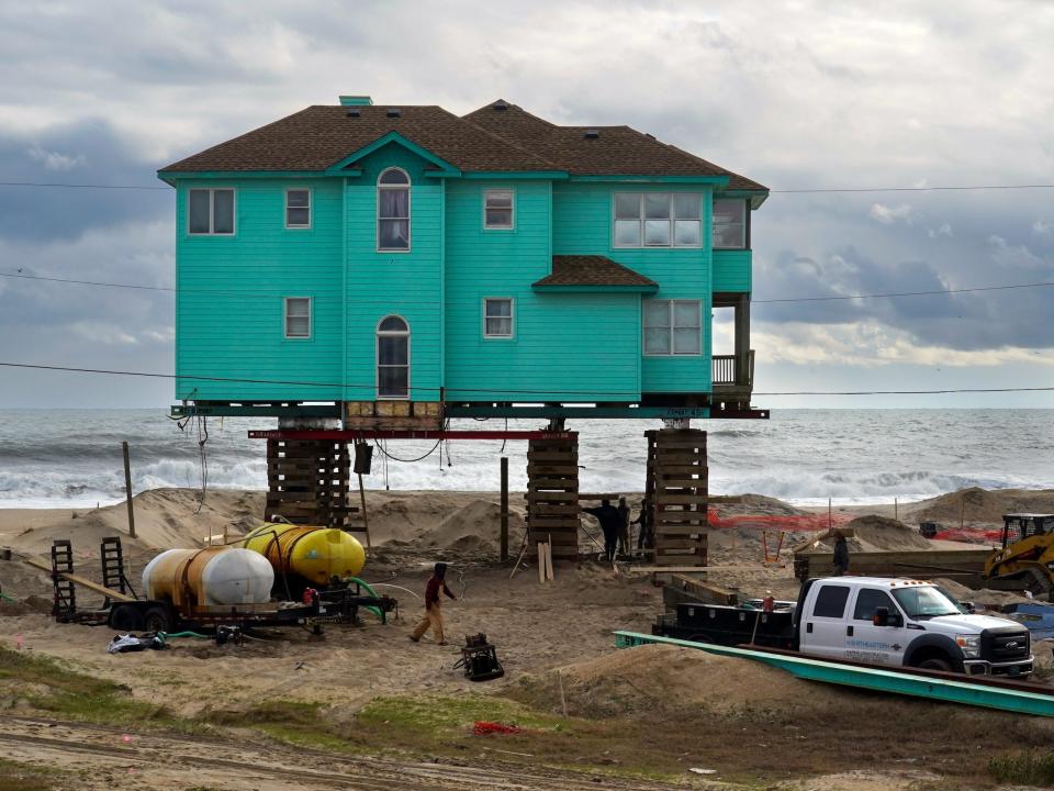 A crew stabilizes a home after it was moved about 50 feet back from where it originally sat in December 2022.