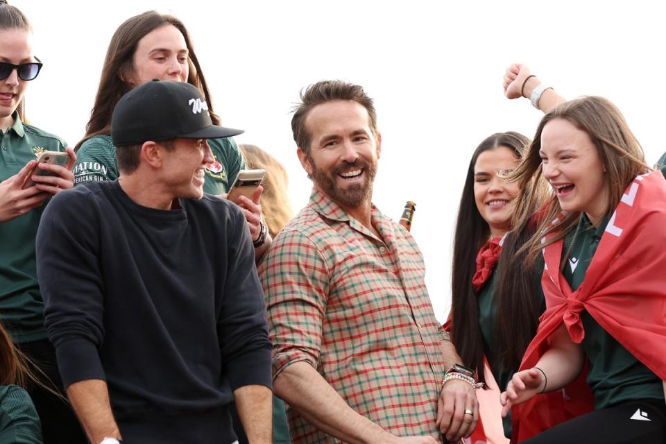 Wrexham co-owners Ryan Reynolds and Rob McElhenney celebrate with players of Wrexham Men and Women during a Wrexham FC Bus Parade (Getty Images)