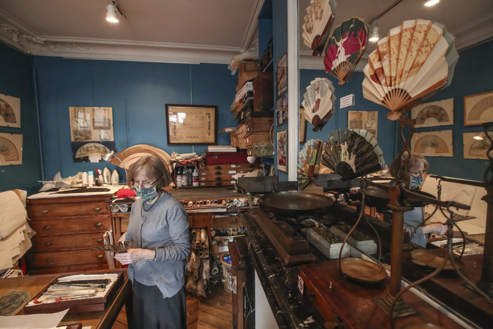 Anne Hoguet, de 74 años, artesana de abanicos y directora del museo del abanico de París trabaja en su taller en el museo en París, el miércoles 20 de enero de 2021. El Musee de l'Eventail de París está en peligro de desaparecer por la pandemia. (Foto AP/Michel Euler)