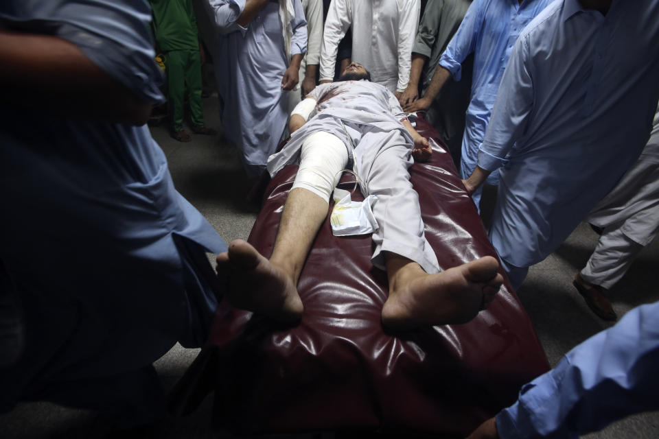 People transport an injured victim of a powerful bomb upon arrival at a hospital in Peshawar, Pakistan, Sunday, July 30, 2023. A bomb ripped through a rally by supporters of a hard-line cleric and political leader in the country's northwestern Bajur district that borders Afghanistan on Sunday, police and health officials said. (AP Photo/Muhammad Sajjad)