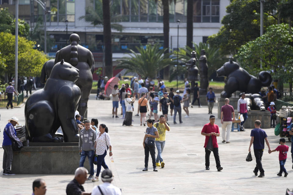 Visitantes caminan por la Plaza Botero de Medellín, Colombia, el jueves 1 de febrero de 2024. La ciudad dejó atrás la guerra con los cárteles, pero aún lidia con decenas de pandillas, el tráfico de drogas y la violencia, aún así vive un momento de esplendor turístico. (AP Foto/Fernando Vergara)