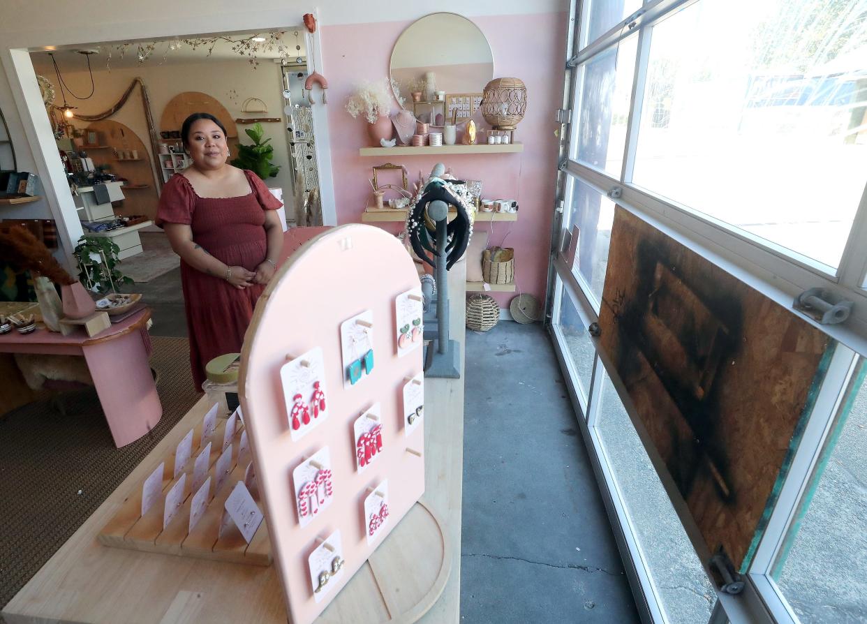 Plywood covers a window at the front of Life in Mauve after a man kicked it in recently. Owner Nayeli Rivera, at left, is closing the shop in July and may move to a location in Manette after numerous incidents with individuals living in the nearby encampment on MLK Way.