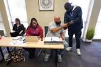 Valentino Smith, right, shows information found on the Internet to Carl Davis, director of operations, seated at right, during a Memphis Allies incident review meeting on Oct. 24, 2022, in Memphis, Tenn. In the meeting, the staff reviews recent shootings in the area and tries to find information about people involved by searching social media and other leads on line. (AP Photo/Mark Humphrey)