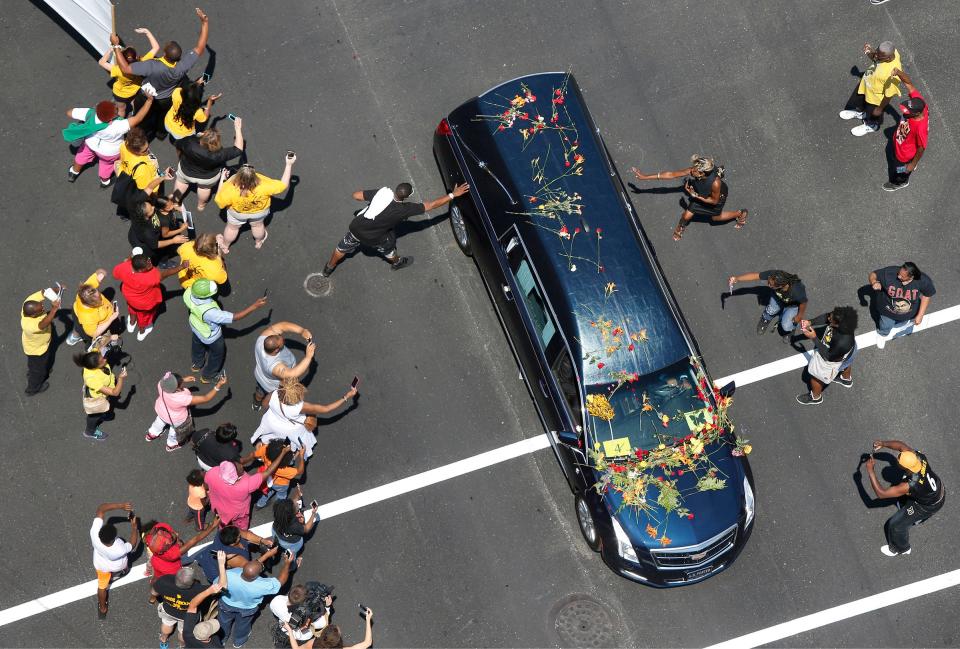 Fans reached out to touch Muhammad Ali's hearse as it made its way east on Broadway, in Louisville, Ky. June 10, 2016.