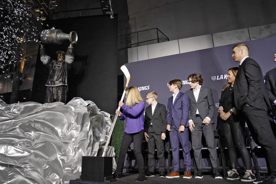 Former Los Angeles Kings right winger Dustin Brown, right, stands with his family as his statue is unveiled prior to an NHL hockey game between the Los Angeles Kings and the Pittsburgh Penguins Saturday, Feb. 11, 2023, in Los Angeles. (AP Photo/Mark J. Terrill)