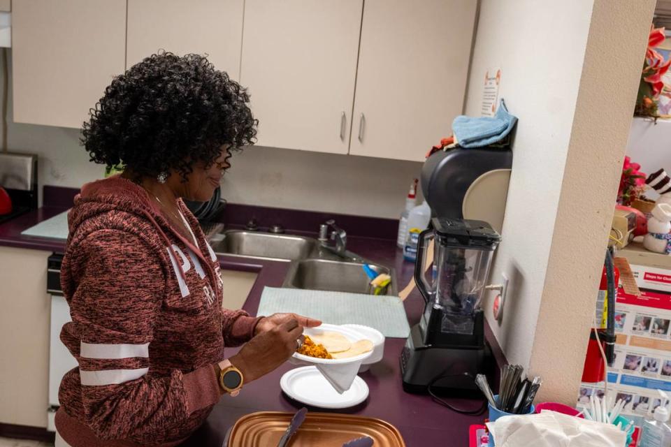 Diane Washington, activities assistant, serves up lunch at the Stanford Settlement Neighborhood Senior Center on Nov. 17, where their kitchen sink needs replacing.