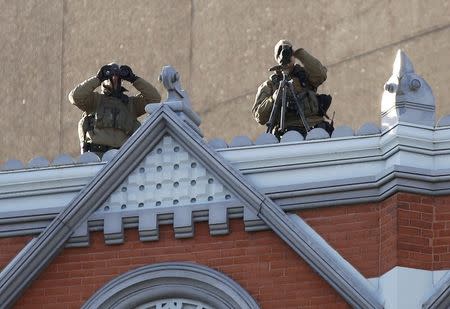 Police spotters keep watch from a high vantage point during Remembrance Day ceremonies at the National War Memorial in Ottawa November 11, 2014. REUTERS/Chris Wattie