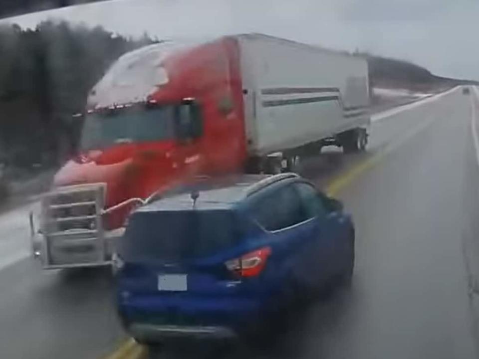 Tony Power captured this high-speed near miss on the Trans-Canada Highway near Doyles, in which a blue SUV narrowly avoids hitting two transport trucks. (Submitted by Tony Power - image credit)