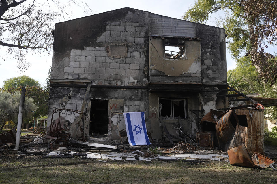 An Israeli flag is placed next to a house destroyed by Hamas militants in Kibbutz Be'eri, Israel, Wednesday, Dec. 20, 2023. The kibbutz was overrun by Hamas militants from the nearby Gaza Strip on Oct.7, when they killed and captured many Israelis. (AP Photo/Ohad Zwigenberg)