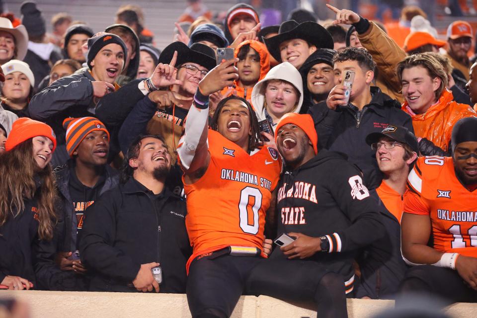 Oklahoma State running back Ollie Gordon II (0) celebrates with fans after Saturday's game against Cincinnati at Boone Pickens Stadium in Stillwater.