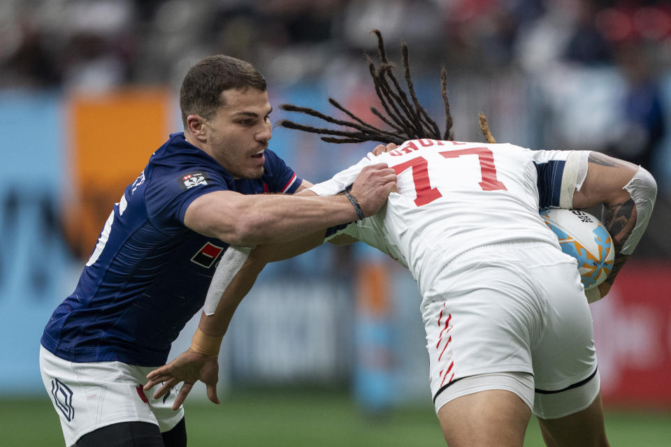 France's Antoine Dupont grabs United States' Maka Unufe during a Vancouver Sevens rugby match Friday, Feb. 23, 2024, in Vancouver, British Columbia. (Ethan Cairns/The Canadian Press via AP)